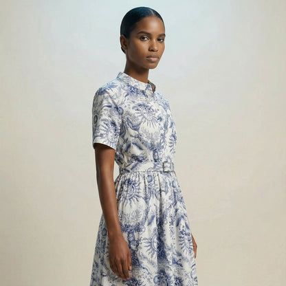 The Veronica midi dress featuring a short-sleeved ribbed knit bodice and a side-pleated accordion skirt with a matching waist belt.