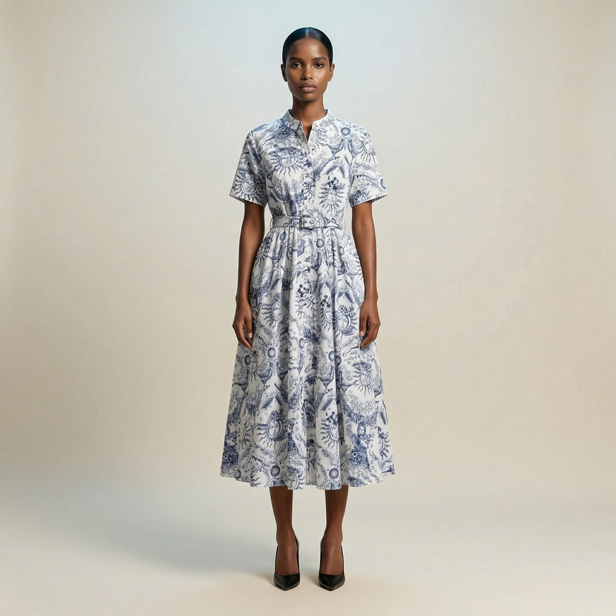 The Veronica midi dress featuring a short-sleeved ribbed knit bodice and a side-pleated accordion skirt with a matching waist belt.