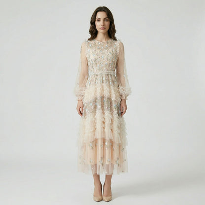 Front view of the Viviane champagne tulle dress featuring pastel floral embroidery, tiered ruffles, and long lantern sleeves displayed on a hanger.