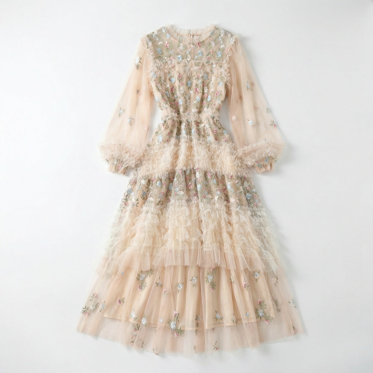Front view of the Viviane champagne tulle dress featuring pastel floral embroidery, tiered ruffles, and long lantern sleeves displayed on a hanger.